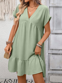 Woman wearing a green dress with a neutral background