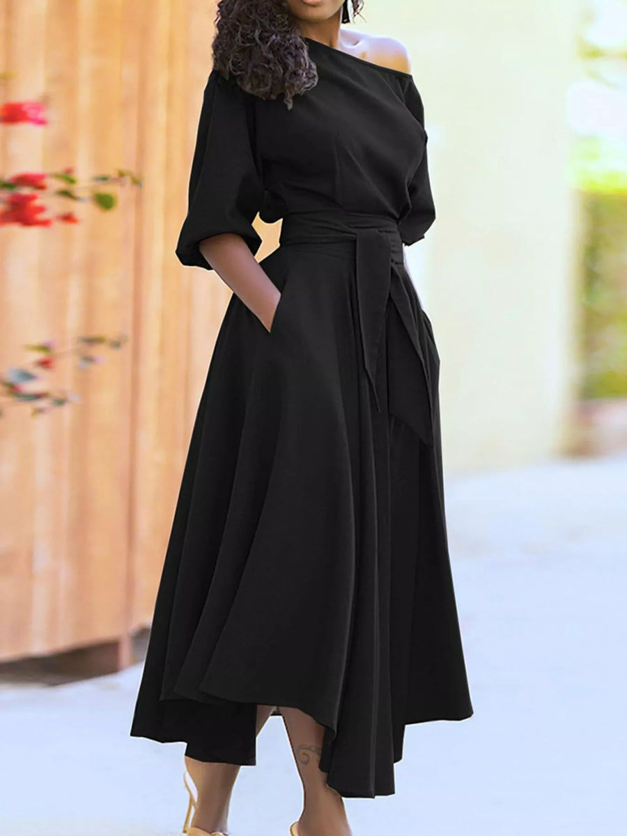 Person wearing a black off-shoulder dress with a blurred floral background