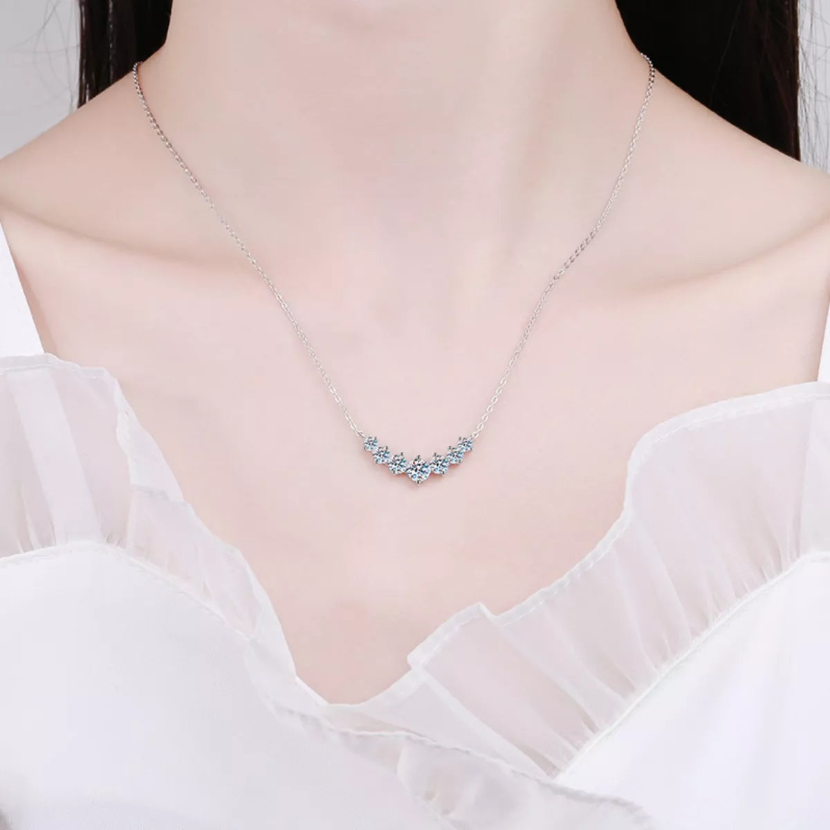 Necklace with blue gemstones on a mannequin wearing a white dress.
