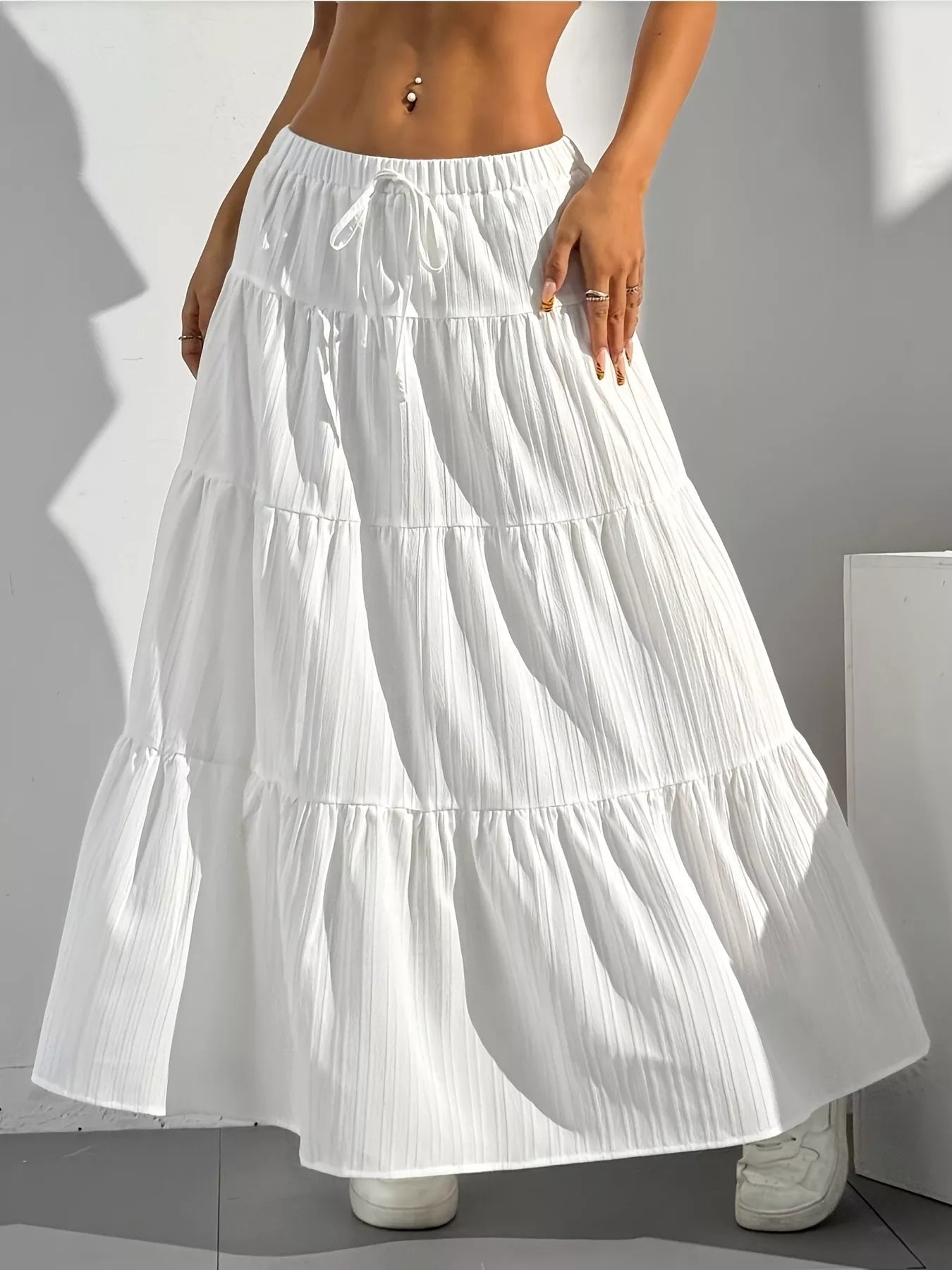 White tiered skirt worn by a person on a gray background
