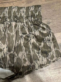 Camouflage-patterned bedspread on a wooden bed frame