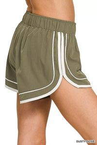 Green athletic shorts with white trim on a white background