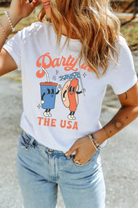 Person wearing a white t-shirt with 'Party in the USA' design, standing outdoors.