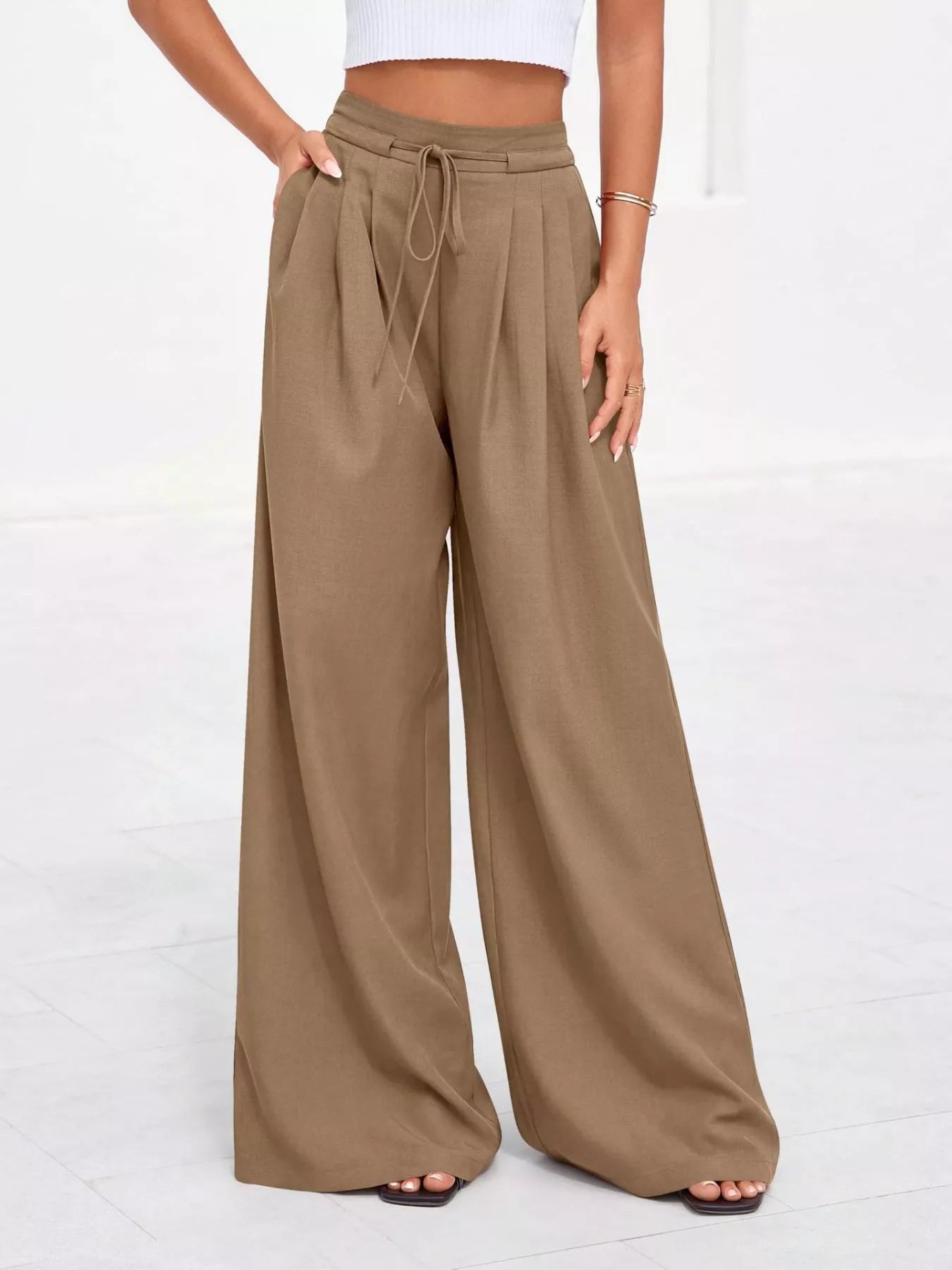 Brown wide-leg pants worn by a person on a white background