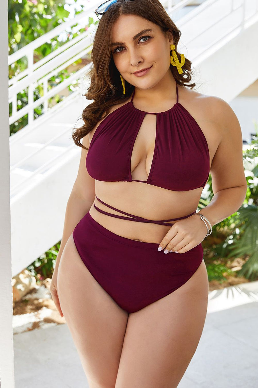 Woman wearing a burgundy bikini set with a white background