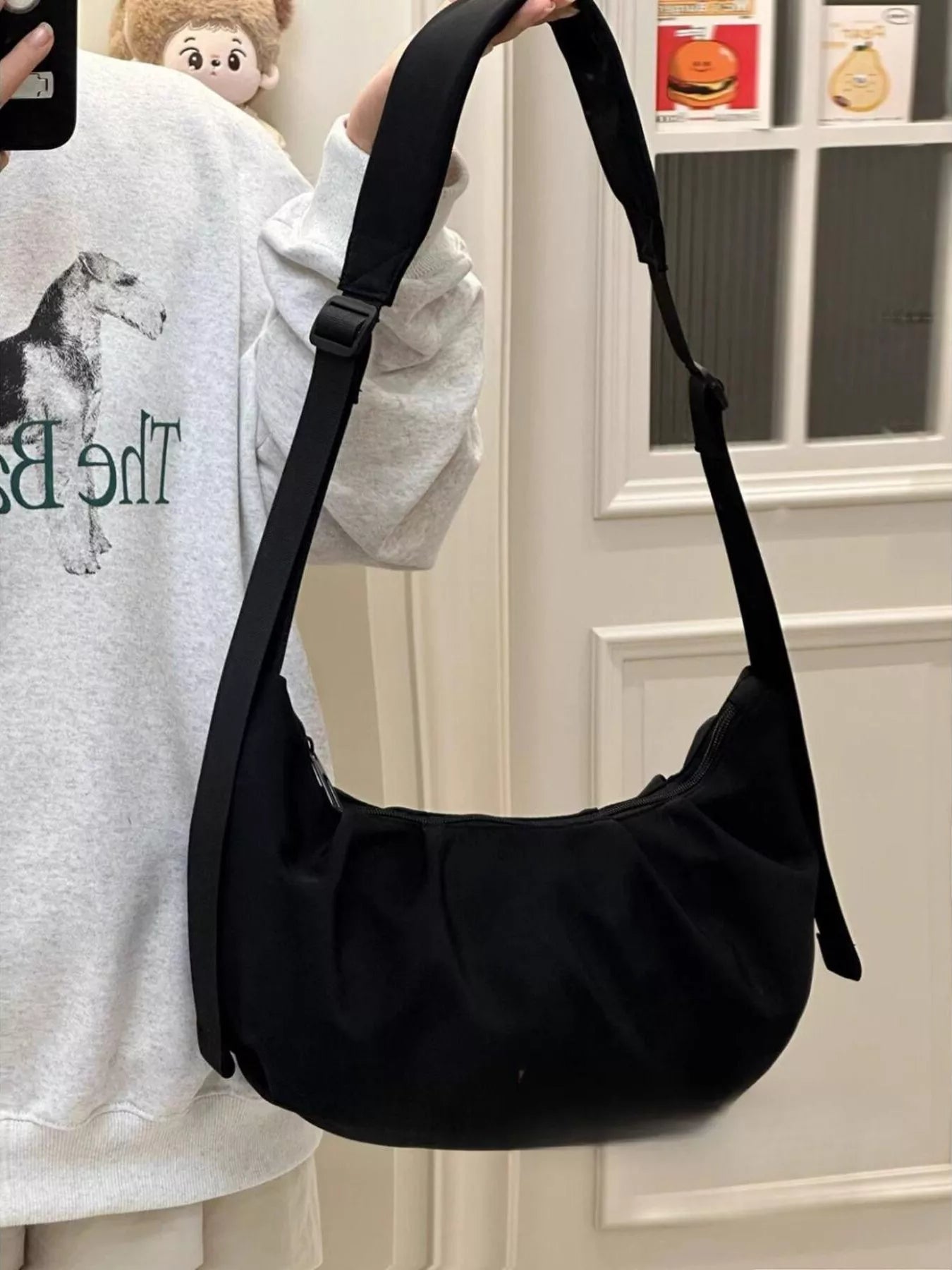 A young lady holding up a black Adjustable Strap Crossbody Bag Purse