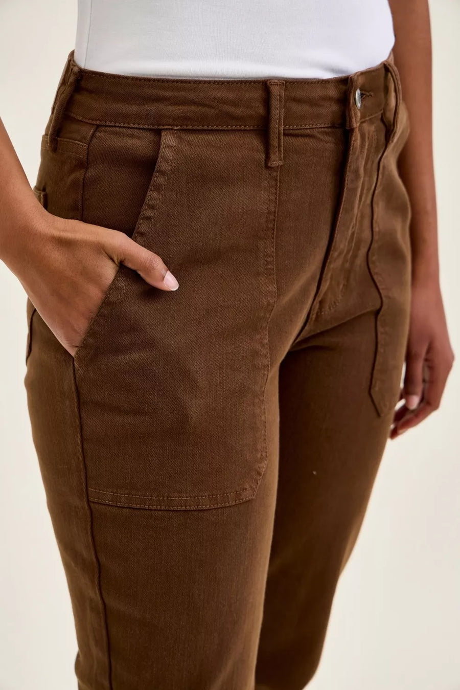 Brown pants worn by a person on a beige background