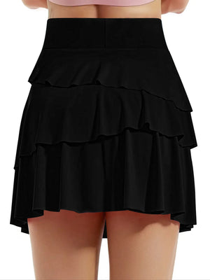 Black tiered skirt worn by a person on a white background