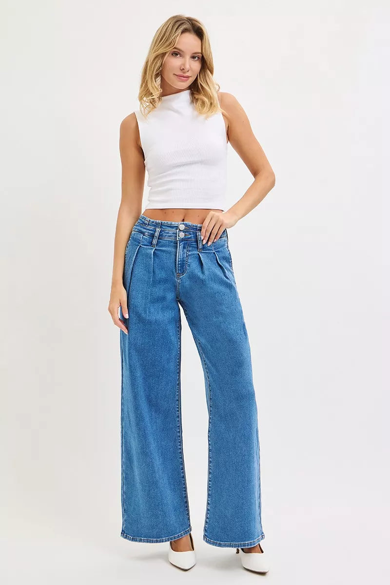 Woman wearing a white sleeveless top and blue jeans on a white background