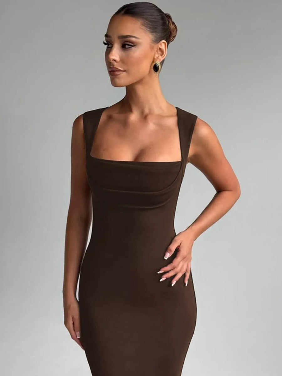 Woman wearing a brown dress against a gray background