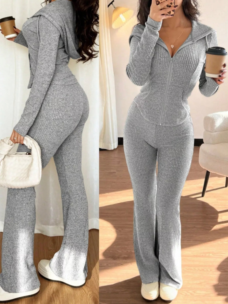 Woman wearing a gray knit outfit with a matching handbag and shoes, holding a coffee cup.