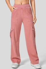 Pink cargo pants worn by a person on a light gray background