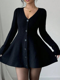 Black cardigan dress worn by a person on a plain background