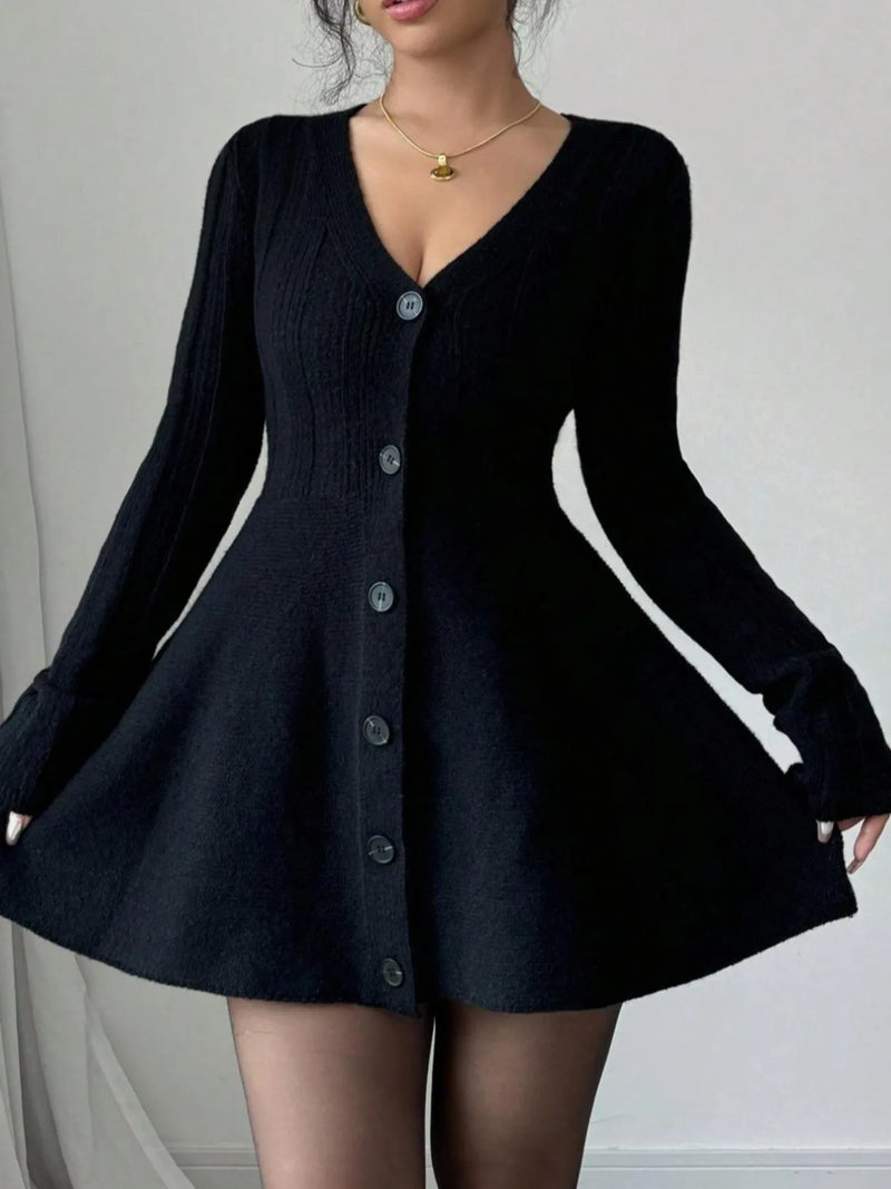 Black cardigan dress worn by a person on a plain background