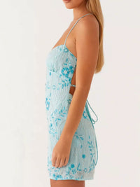 Woman wearing a light blue floral dress on a white background