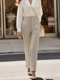 Person wearing a beige suit walking on a city street.