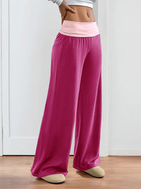 Pink wide-leg pants worn by a person on a white background