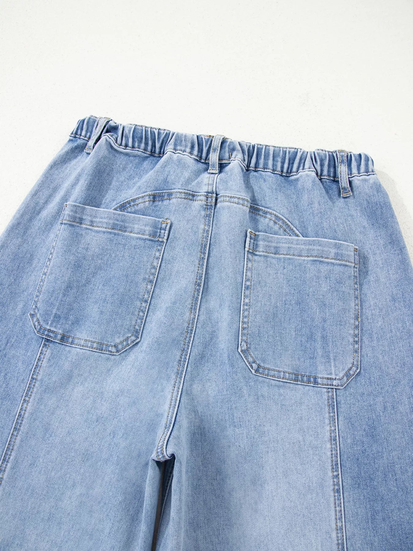 Light blue denim pants with a white background