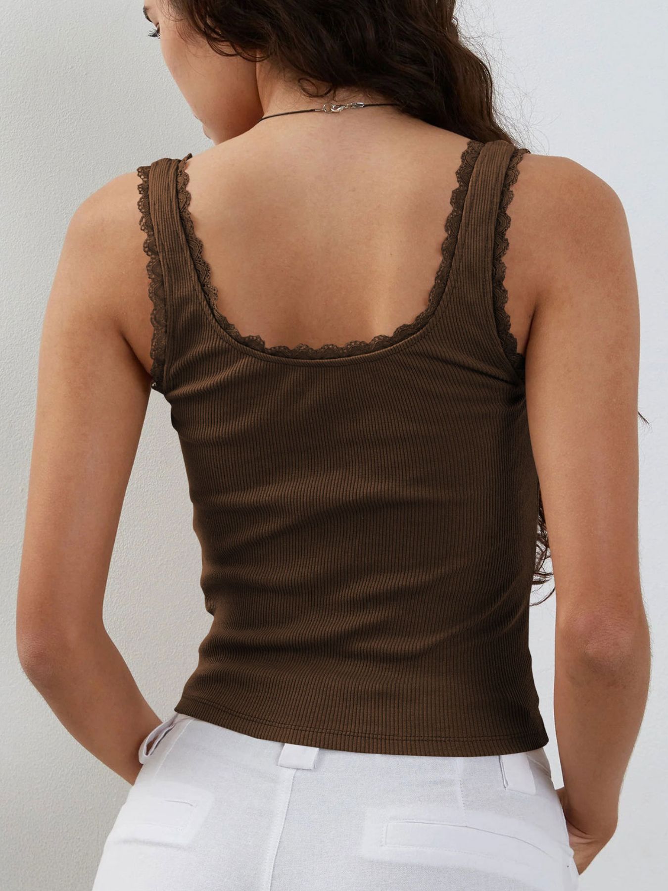 Brown tank top with lace trim worn by a person on a white background