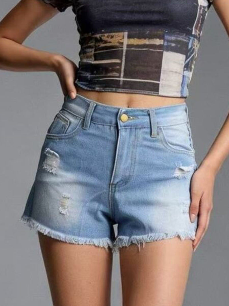 Person wearing a black and white patterned crop top and blue denim shorts on a gray background