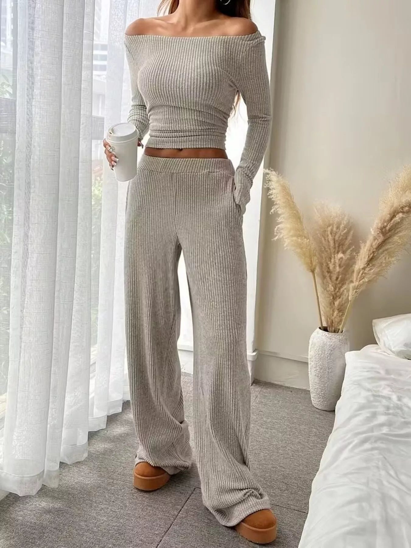 Person wearing a gray ribbed knit outfit in a bedroom setting.