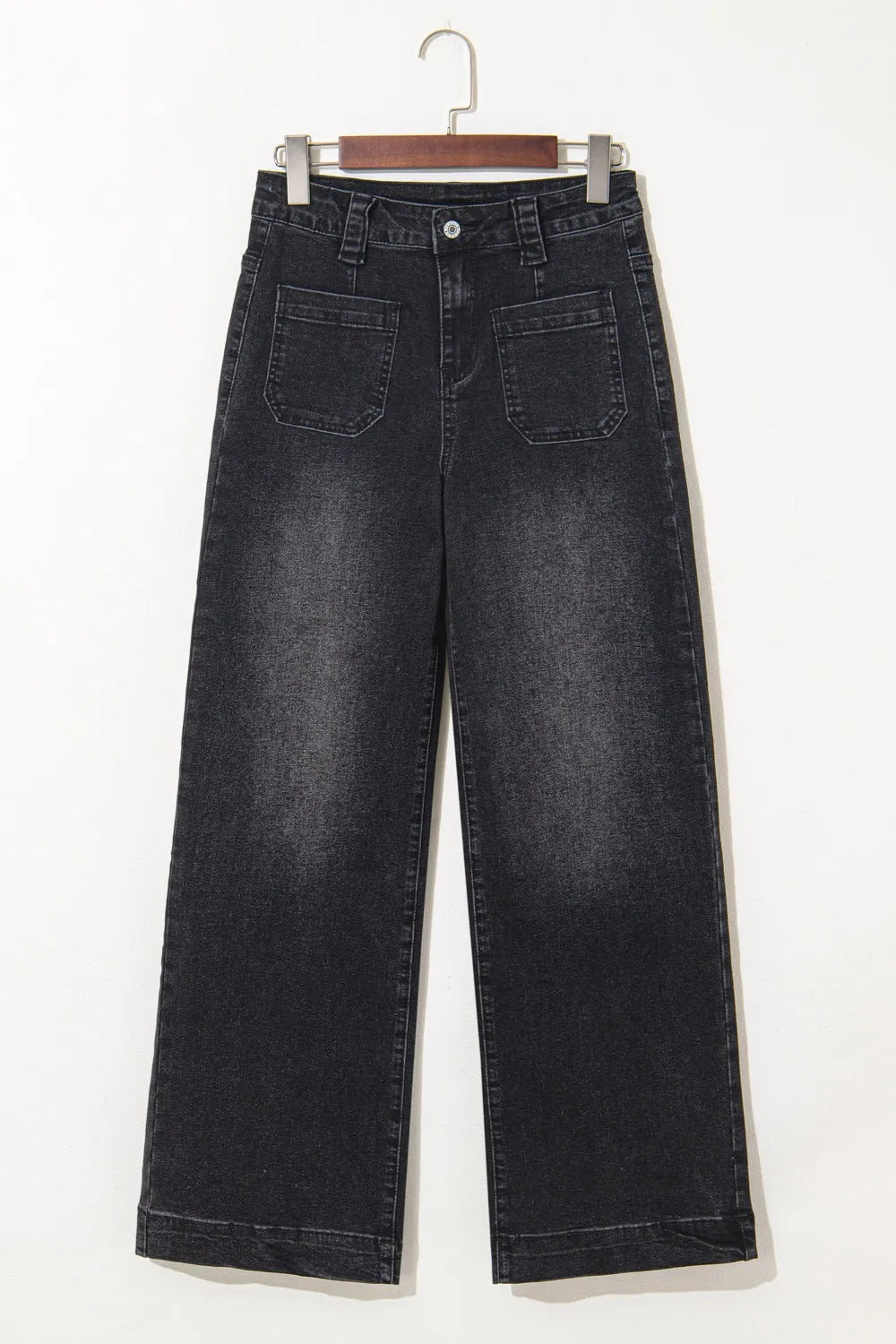 Black wide-leg jeans on a hanger against a white background
