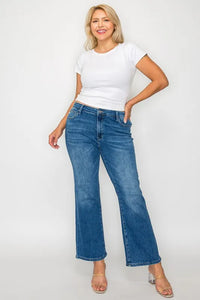 Woman wearing a white t-shirt and blue jeans on a plain background