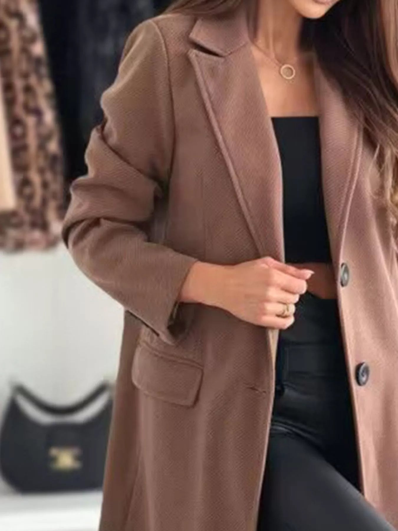 Person wearing a brown coat with a blurred background