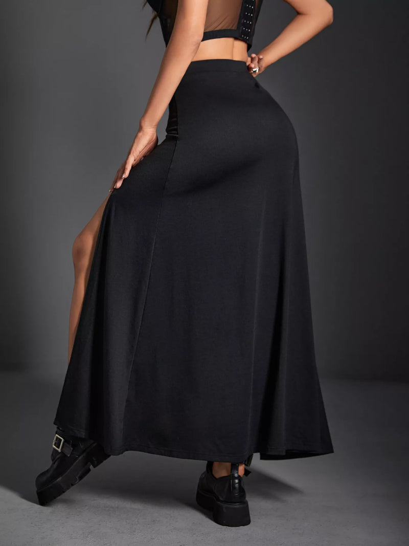 Person wearing a black long skirt with a gray background