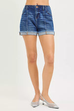 Denim shorts worn by a person on a white background