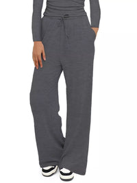 Gray sweatpants worn by a person on a white background