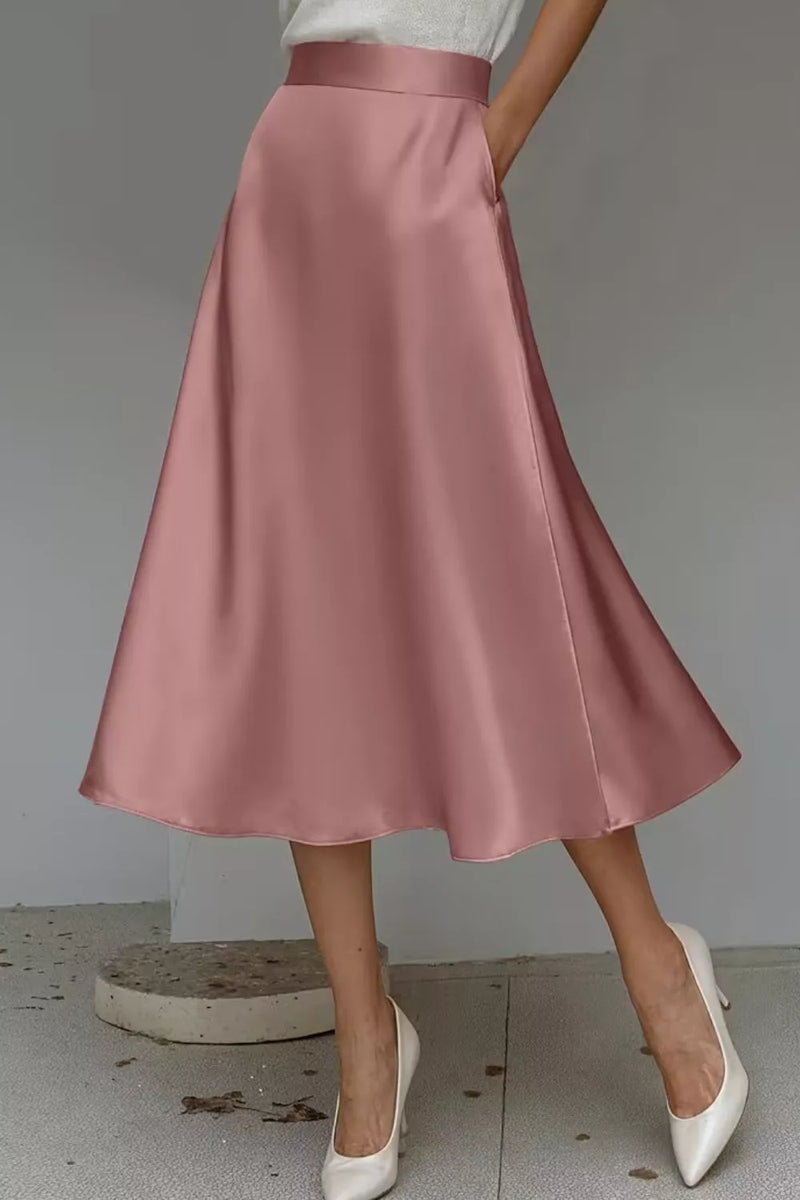 Pink satin skirt worn by a person on a neutral background