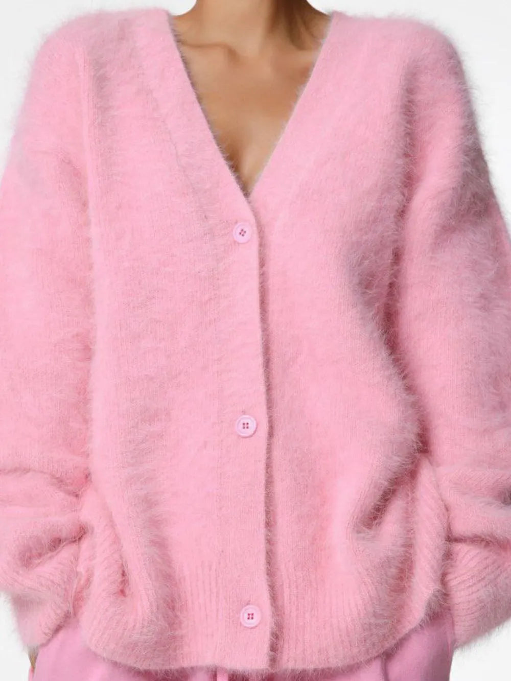 Pink cardigan worn by a person on a white background