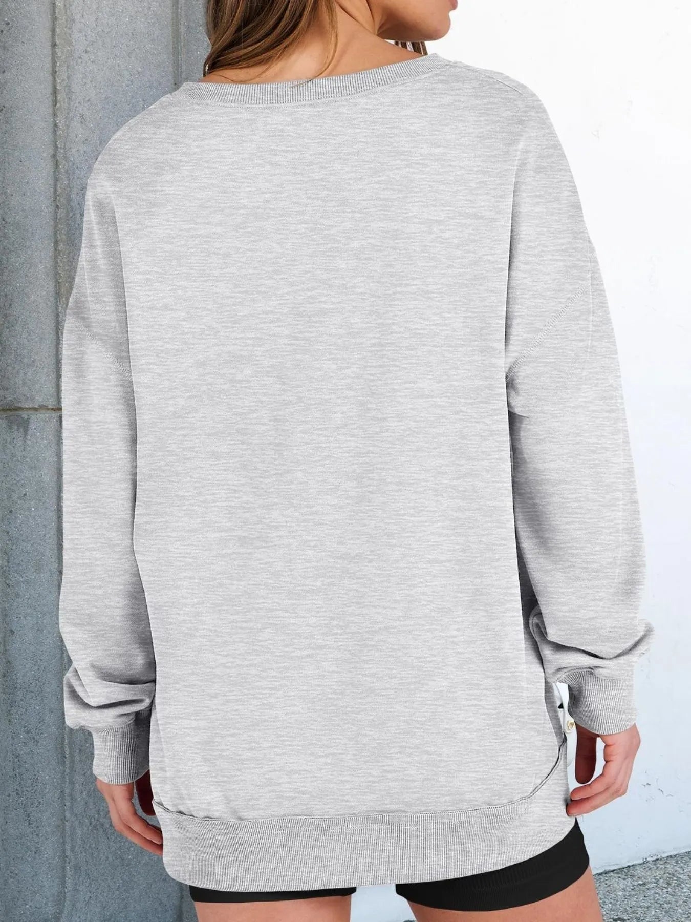 Person wearing a gray sweatshirt with a neutral background