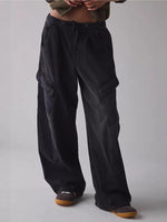 Person wearing black cargo pants on a plain background