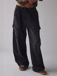 Person wearing black cargo pants on a plain background