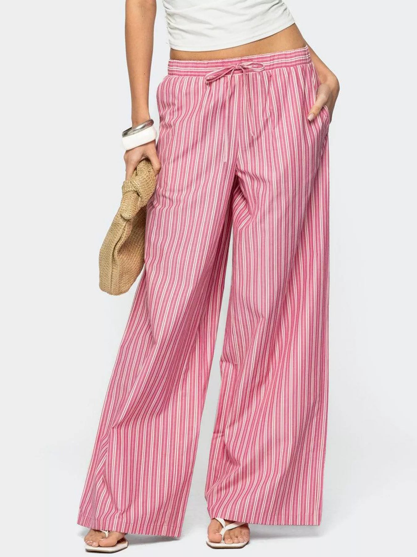 Person wearing pink and white striped pants on a white background