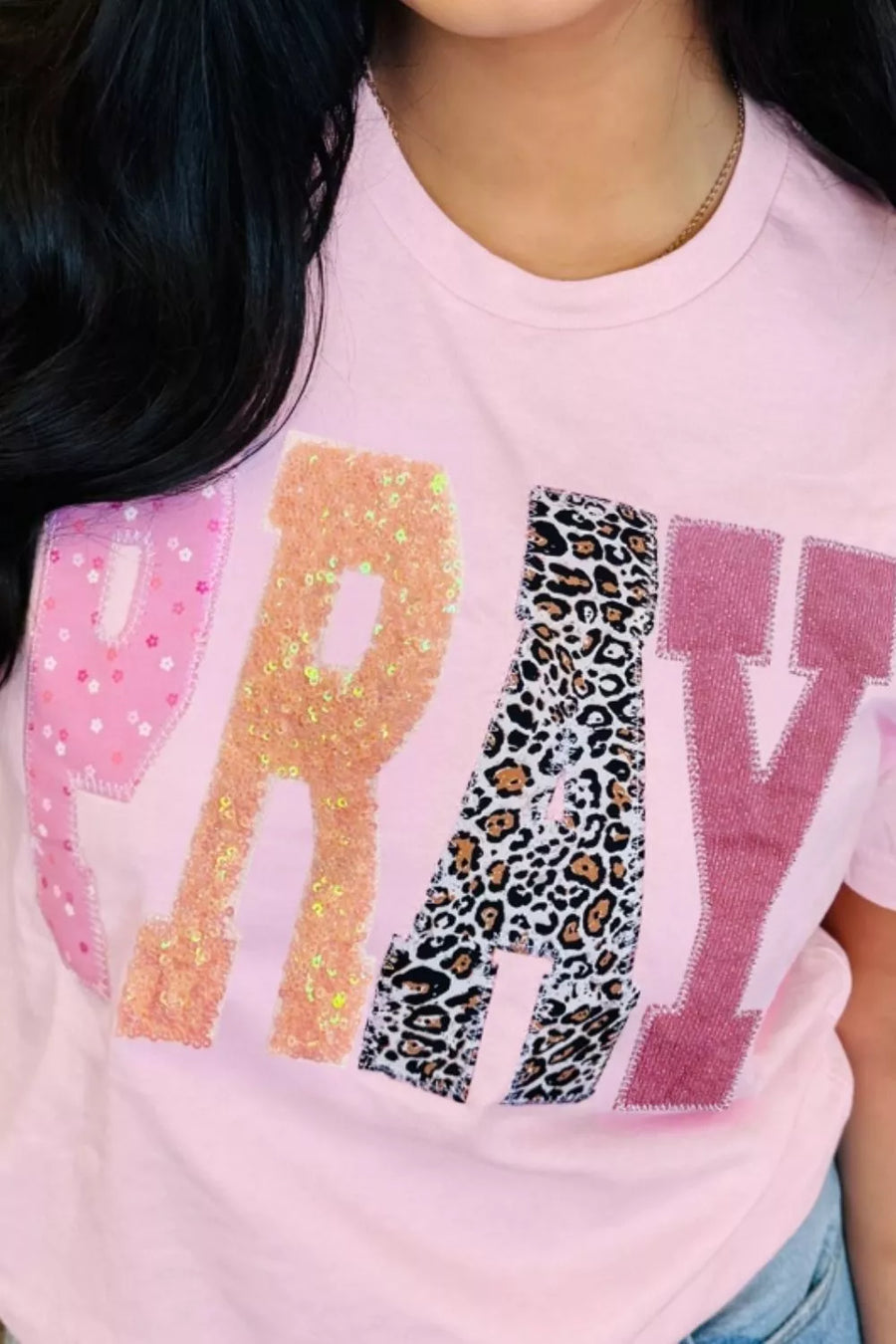 Pink t-shirt with colorful text design featuring glitter and leopard print.