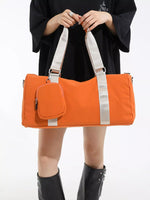 Person holding an orange duffel bag with a white background