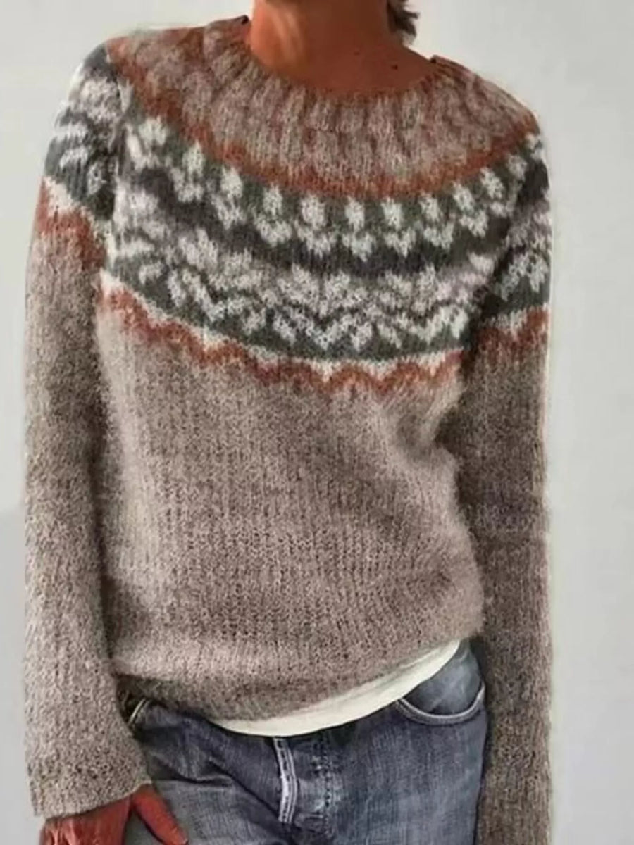 Person wearing a patterned sweater with a neutral background