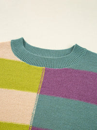 Color-blocked sweater with green, purple, and beige sections on a light background