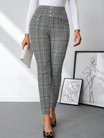Person wearing black and white checkered pants in a minimalistic room.