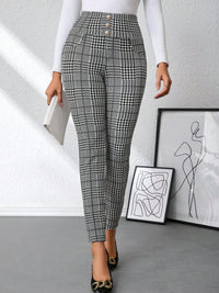 Person wearing black and white checkered pants in a minimalistic room.