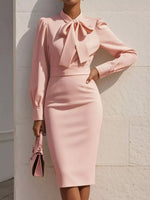 Person wearing a pink dress with a bow detail against a light background