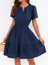 Woman wearing a navy blue dress with a white background