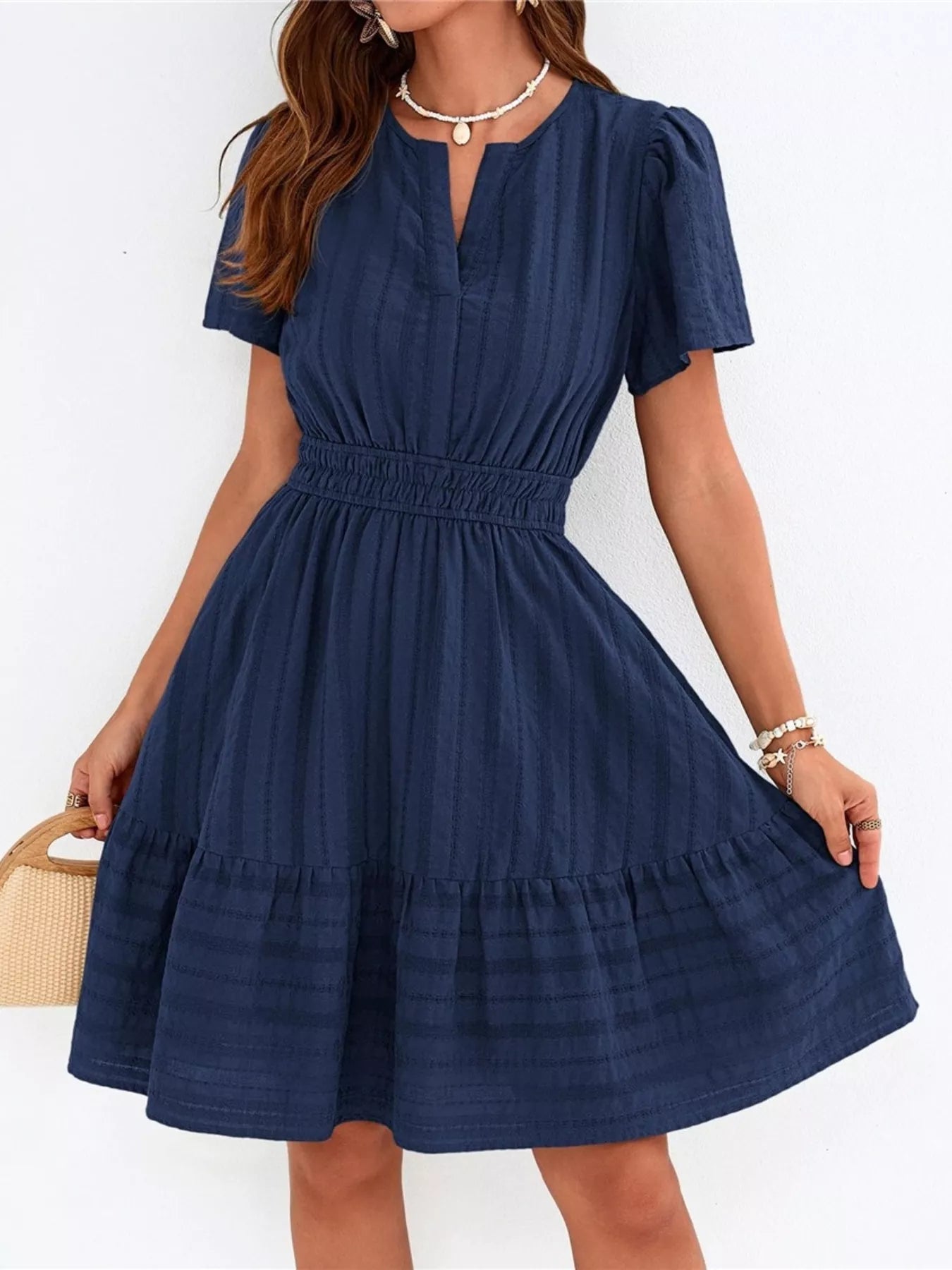 Woman wearing a navy blue dress with a white background