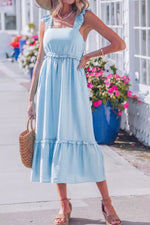 Woman wearing a light blue dress with a floral background