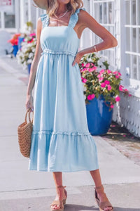 Woman wearing a light blue dress with a floral background