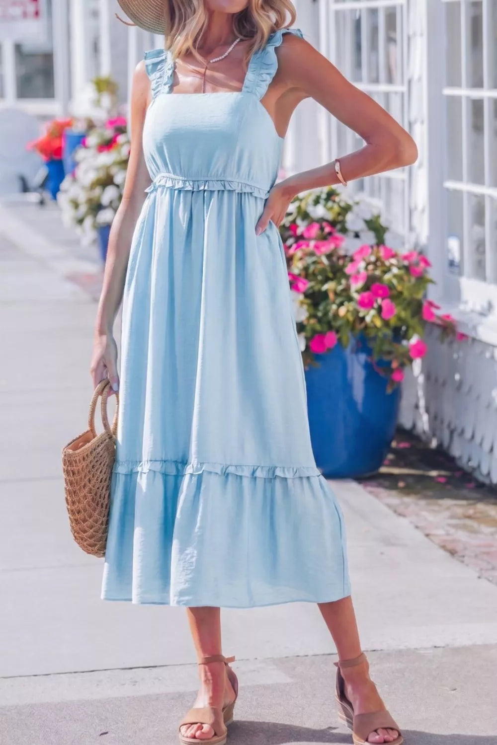 Woman wearing a light blue dress with a floral background