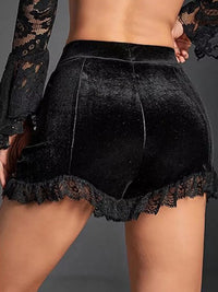 Black lace shorts worn by a person on a gray background